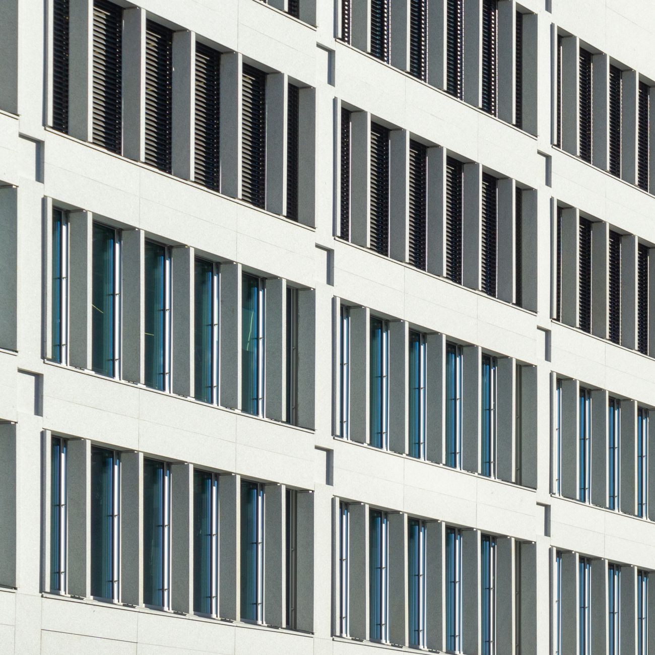 Lys kontorbygning med rækker af vinduer